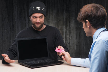 Bearded theft proposing to businessman to shop online with card. Internet theft conceptの写真素材