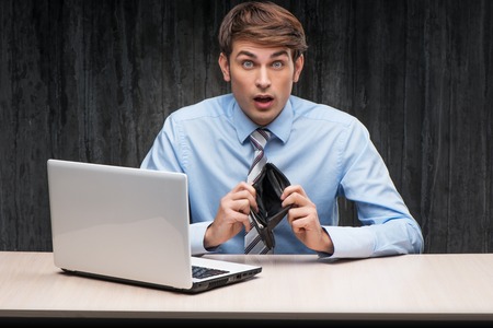 Shocked white collar businessman with empty wallet. Internet theft conceptの写真素材