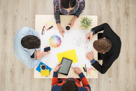 Top view of round table with group of busy creative people working on project. Sturt up conceptの写真素材