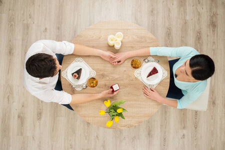 Top view of round table with couple on date. Proposal of marriage conceptの写真素材