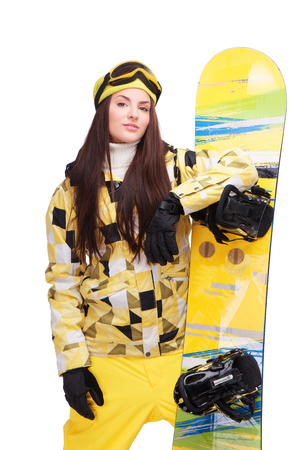 Beautiful young woman in winter clothes holding snowboard, isolated on white backgroundの写真素材