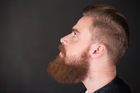 Profile of stylish young man with beard looking upの写真素材