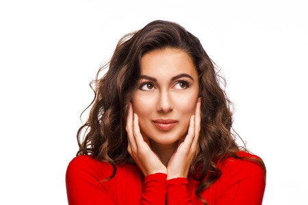 Close up portrait of gorgeous woman looking aside with curly hair in red dress, isolated on white backgroundの写真素材