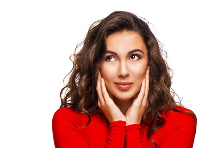 Close up portrait of gorgeous woman looking aside with curly hair in red dress, isolated on white backgroundの写真素材