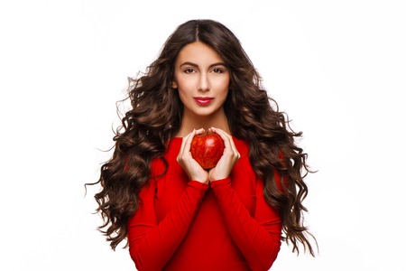 Beautiful young woman with curly hair holding red apple, isolated on white background.の写真素材