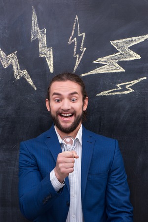 Excitement man with beard standing on the? blackboard backgroundの写真素材