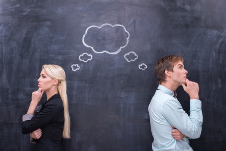 Male and female thinking together on th blackboard backgroundの写真素材