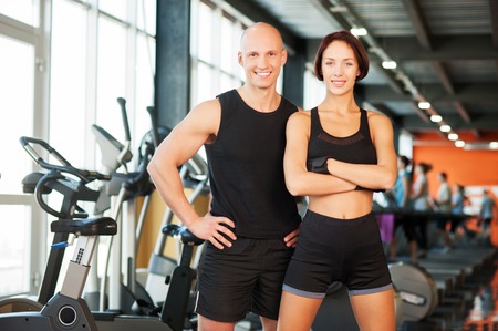 Young man and woman relaxing in sports outfits at the gymの写真素材