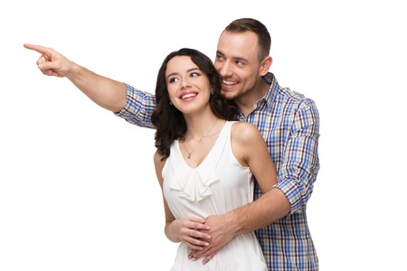 Man points at something. Both lovers looking at something with interest. Isolated on white backgroundの写真素材