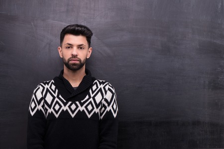 Photo of handsome young stylish man on blank chalkboard backgroundの写真素材