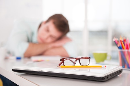 Close up of young tired businessman. He sleeping while working day. Office interior with windowの写真素材