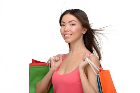 Asian beautiful young woman looking at camera. She holding colorful paper bags. Concept for shop sales. Isolated on white backgroundの写真素材