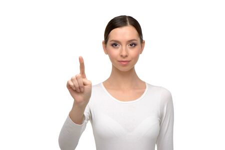 Young woman looking at camera and pointing at something. Isolated on white backgroundの写真素材