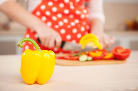 Close up photo of woman chopping paprika for salad. Concept for cooking in the kitchenの写真素材