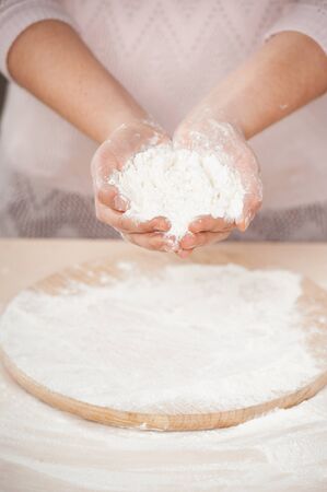 Close up photo of flour in female hands. Concept for cooking in the kitchenの写真素材