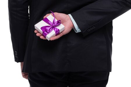 Close up photo of man hand holding small present behind back. の写真素材