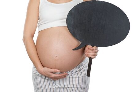 Close up photo of young pregnant woman belly. Woman holding dialog cloud near her belly. Isolated on white background. Concept for pregnancyの写真素材