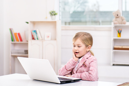 Funny picture of little cute girl playing role of business woman. Girl wearing pink suit. Girl...