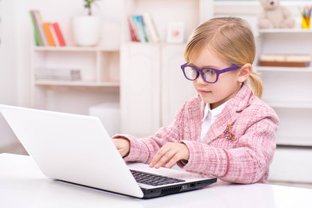 Funny picture of little cute girl playing role of business woman. Girl wearing pink suit and...