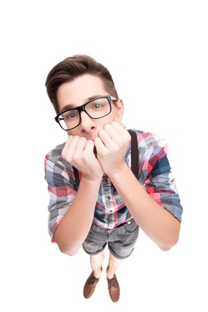 Stressed boy with eyeglasses biting fingernails, isolated on white backgroundの写真素材