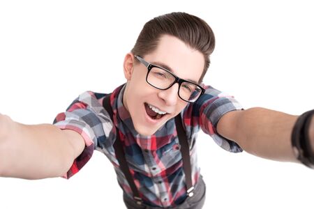 Happy young nerd in glasses and checkered shirt isolated on white backgroundの写真素材