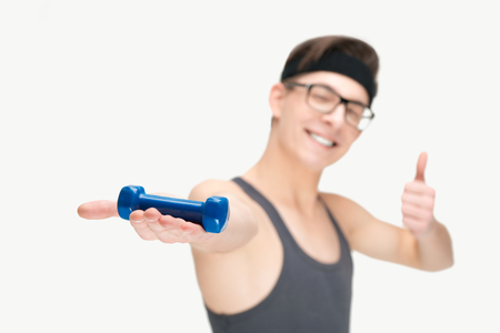 Funny sporty nerd in glasses and dumbbell gesturing thumb up isolated on white backgroundの写真素材