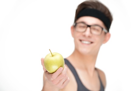 Funny sporty nerd in glasses with apple isolated on white backgroundの写真素材