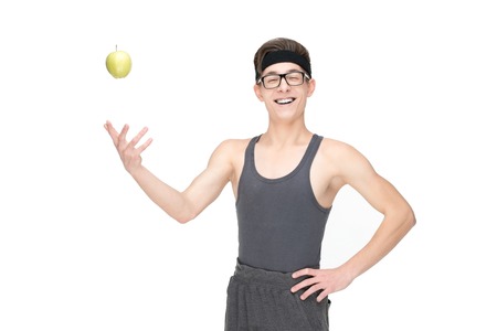 Funny sporty nerd in glasses with apple isolated on white backgroundの写真素材