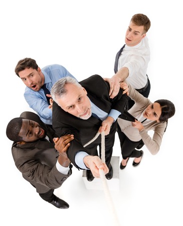 Top view of aged businessman reaching up along rope. Other members of business team preventing him from doing it. Isolated on white backgroundの写真素材