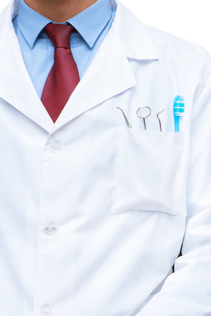 Close up photo of dentist. There are dental instruments and toothbrush in his pocket. Vertical photoの写真素材