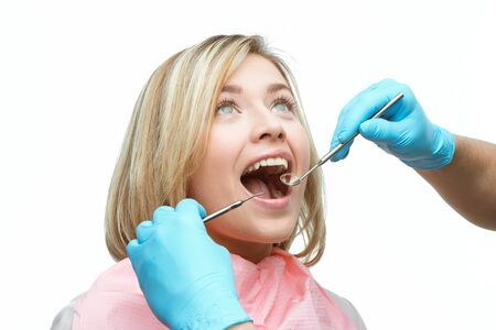 Photo of young woman while dental checkup. Dentist holding dental instrumentsの写真素材