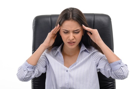 Portrait of young tired businesswoman with headache. She holding hands on temples. Isolated on white...