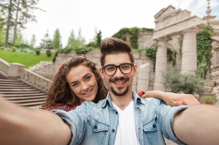 Portrait of beautiful young woman and handsome man on vacation. Girl and boy making self portrait and smilingの写真素材