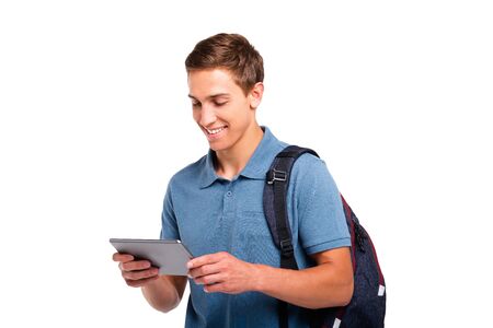 Young student boy smiling and using tablet computer. Isolated on white backgroundの写真素材