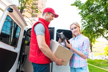 Colorful picture of courier delivers package for woman. Woman is receiving the parcel and smiling.