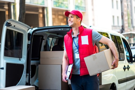 Colorful picture of courier delivers package. Courier holding the box and smiling.