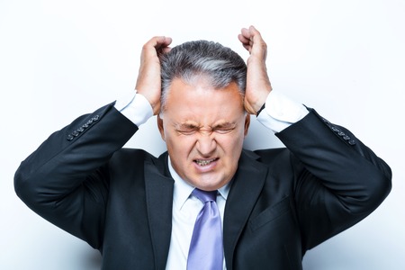 Angry and sad aged businessman on white background.の写真素材