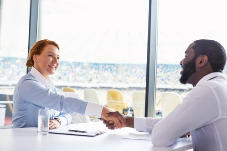 Photo of creative multi ethnic business people. Mixed race business people smiling and shaking hands...