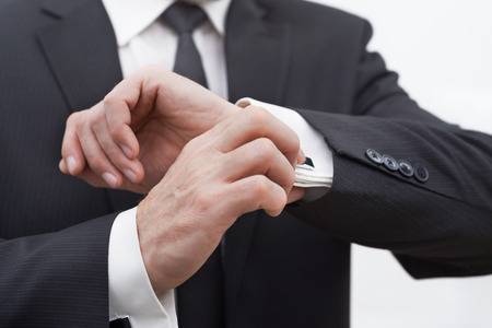 Close au photo of aged businessman wearing suit and tie. Businessman in years straightening cuffsの写真素材