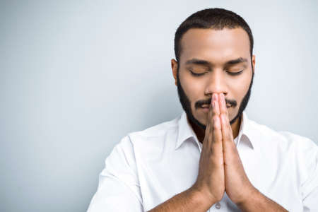 Young mixed race man with beard standing on grey background. Young man with eyes closedの写真素材