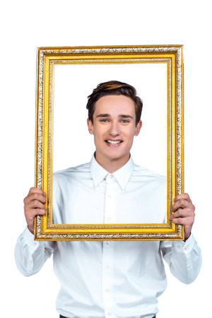 Portrait of young businessman standing on white background, smiling and looking at camera through frameの写真素材