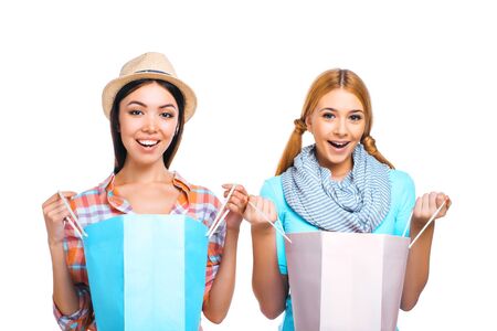 Colorful portrait of beautiful girls on white background. Teenagers holding paper bagsの写真素材