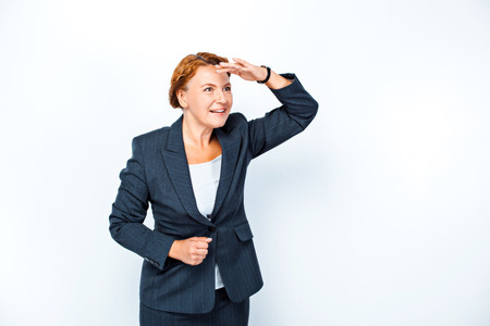 Studio shot of beautiful redheaded business woman. Business woman smiling, looking into distanceの写真素材