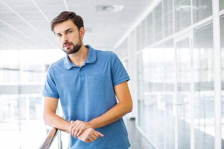 Portrait of young businessman. Man looking at camera and standing in nice modern building. Office interiorの写真素材