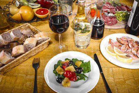 Close up creative photo of delicious meal on wooden vintage table. Focus on plate with saladの写真素材