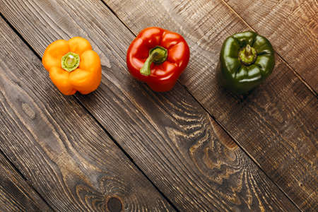 Top view studio shot of fresh vegetables on wooden table. There are peppers on tableの写真素材