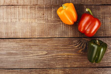 Top view studio shot of fresh vegetables on wooden table. There are peppers on tableの写真素材