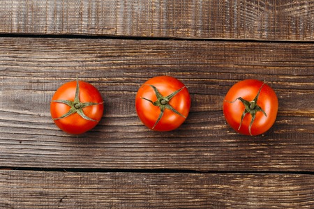 Top view studio shot of fresh vegetables on wooden table. There are tomato on tableの写真素材