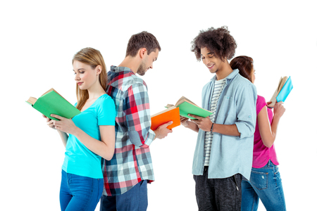 Studio shot of nice young multicultural friends. Beautiful people reading books and smiling. Isolated backgroundの写真素材