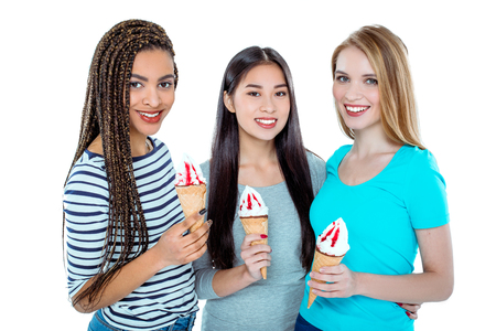 Studio shot of nice young friends. Beautiful girls looking at camera, holding ice-creams and smiling. Isolated backgroundの写真素材
